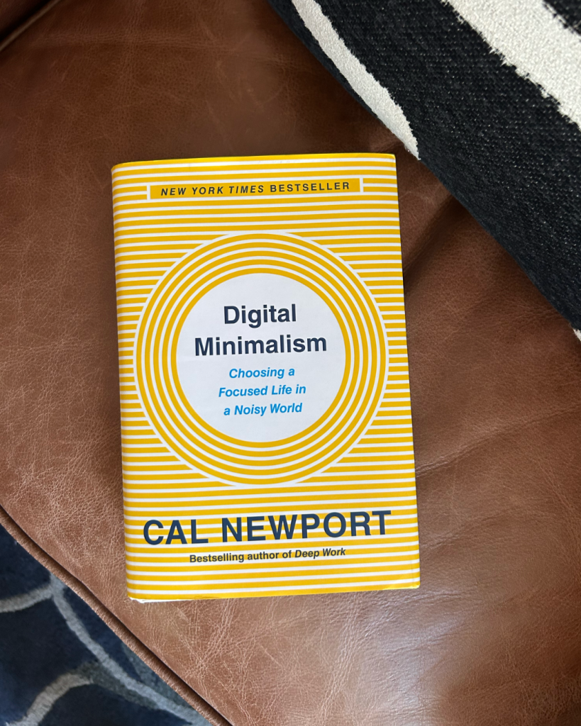 Digital Minimalism book by Cal Newport sitting on a brown leather chair with a black and white pillow.